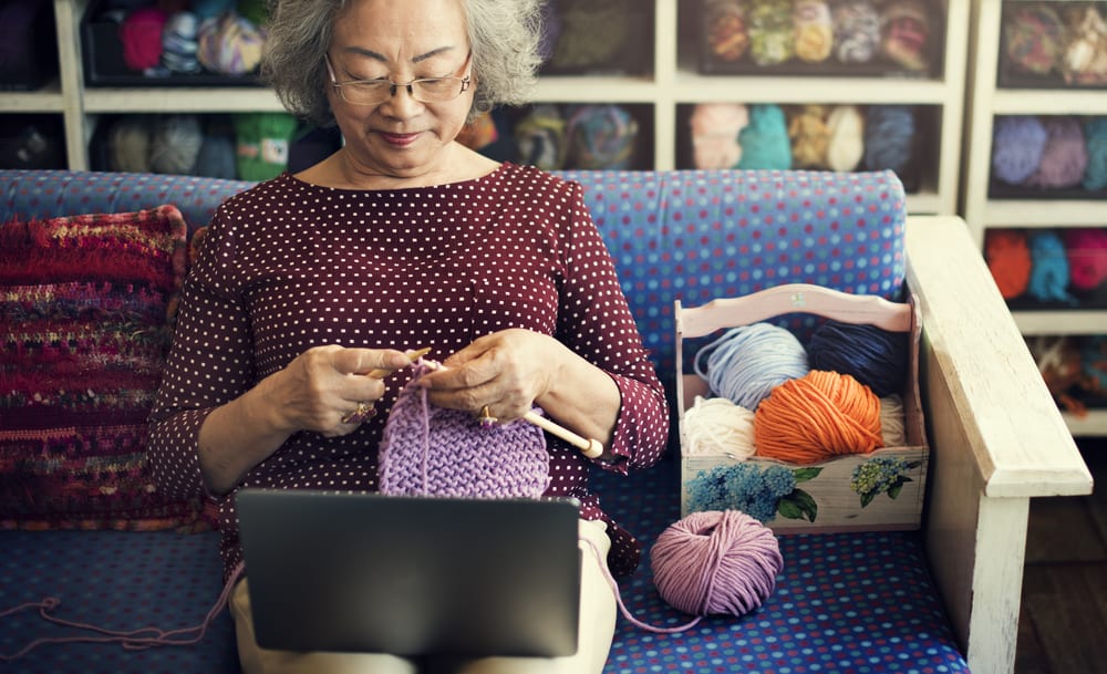 Senior woman crocheting at home