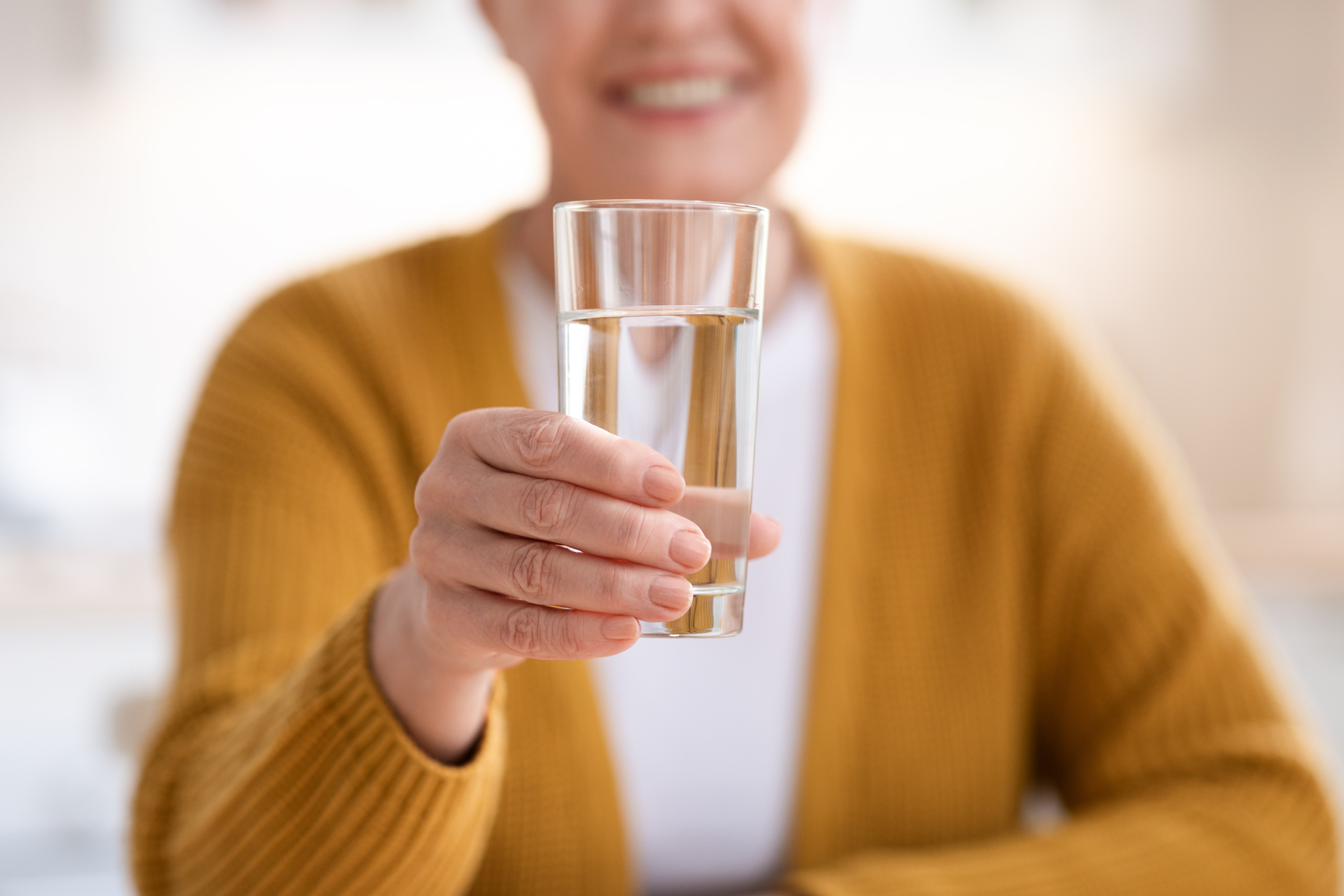 close-up of senior woman drinking glass of water