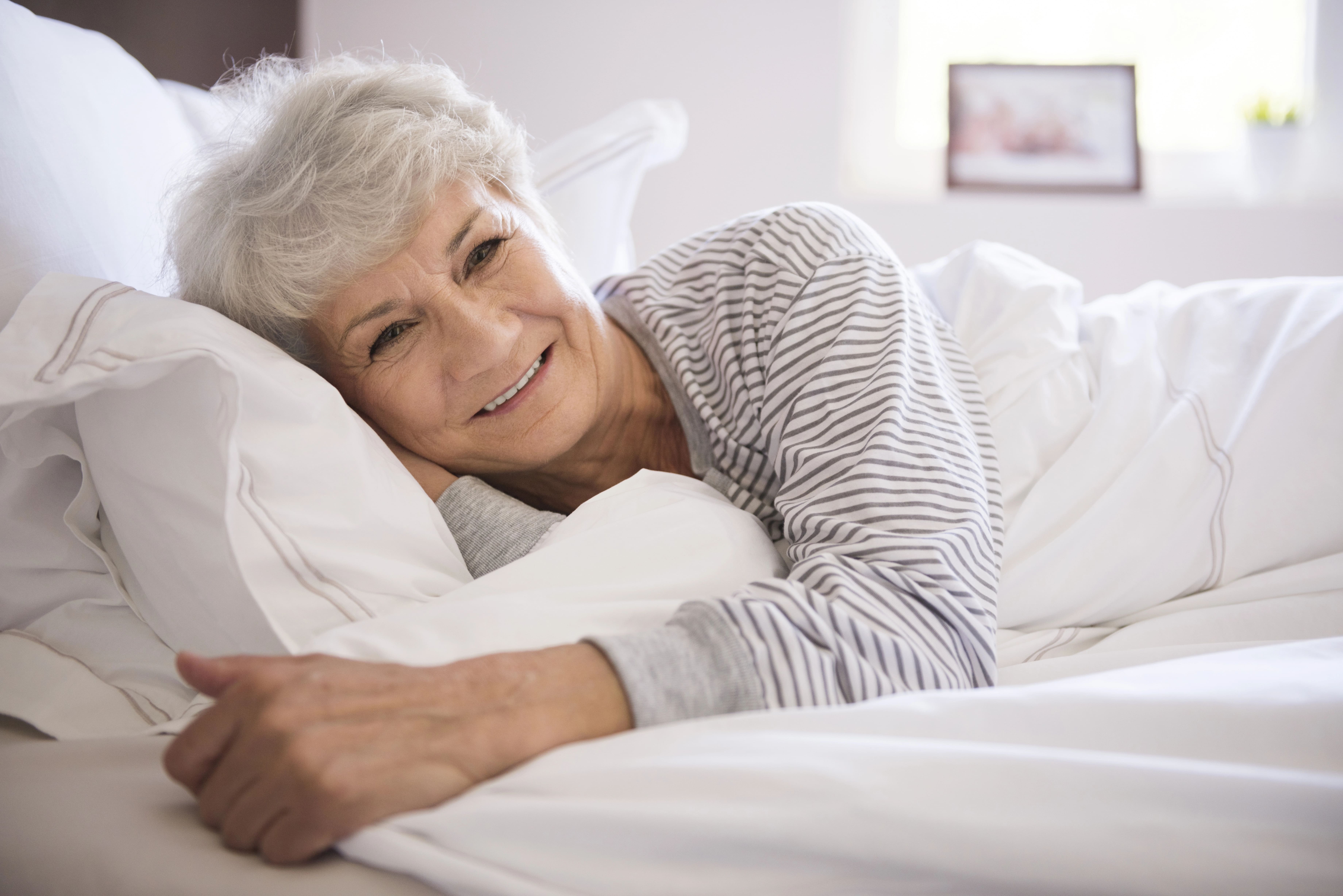 senior woman smiling in bed
